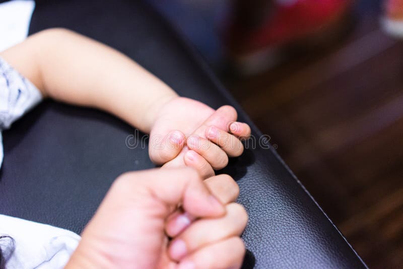 Um menino está guardando seu dedo do pai para mostrar sua confiança e acredita-o imagem de stock Um menino está guardando seu dedo do pai para mostrar sua confiança e acredita-o imagem de stock