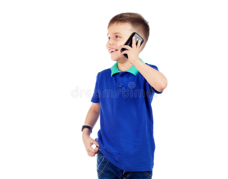 Um menino pré-escolar em um t-shirt azul está falando no telefone e na manutenção programada imagem de stock Um menino pré-escolar em um t-shirt azul está falando no telefone e na manutenção programada imagem de stock