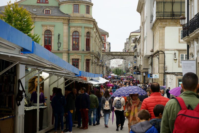 Um mercado de rua movimentado com as pessoas comprando fotografia de stock