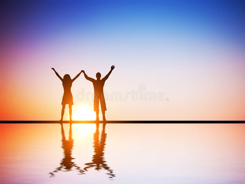 A happy couple in love standing together with hands raised at sunset with water reflection. A happy couple in love standing together with hands raised at sunset with water reflection