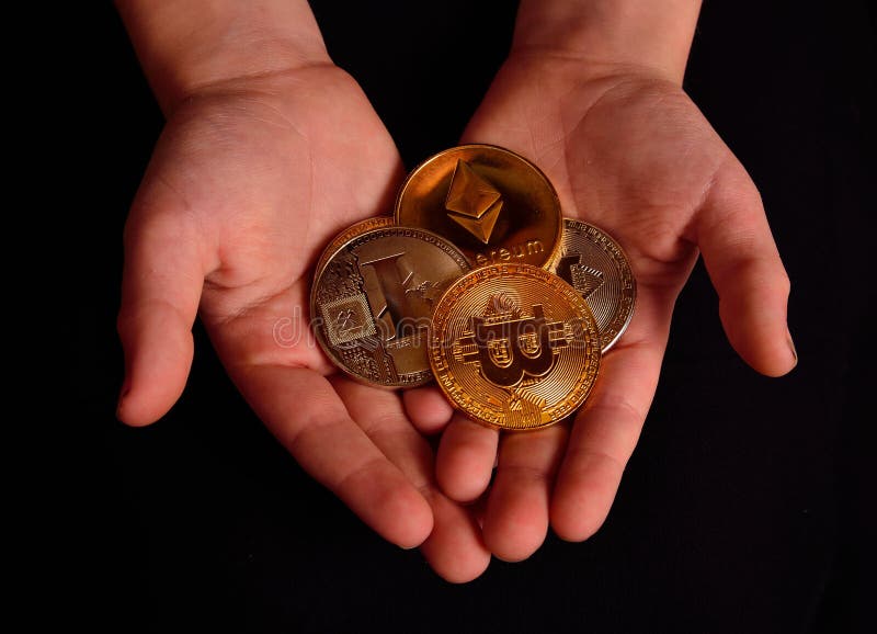 Um par jovem de mãos que detenha vários tipos de moedas de criptomoeda imagens de stock