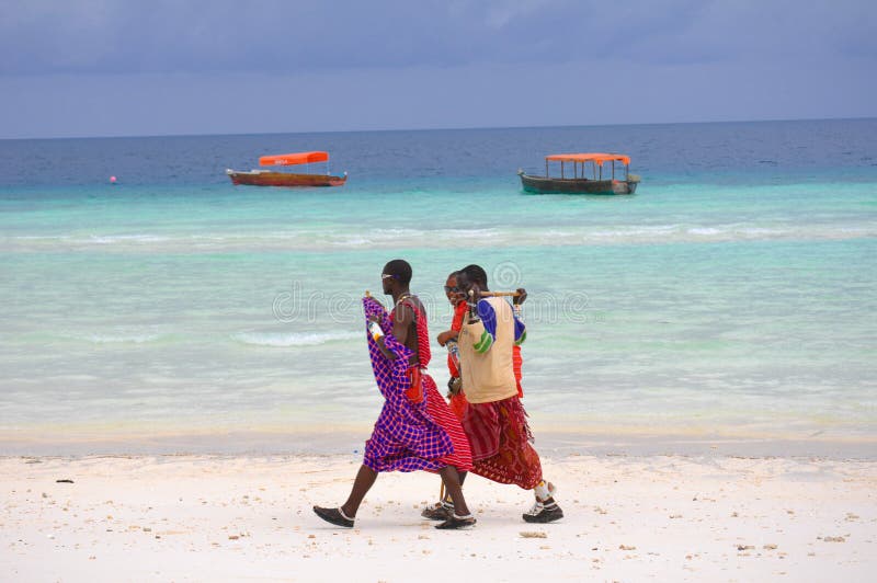 Gentlemen from the native tribe stroll along the white sand coast of Zanzibar after a day of fishing. Gentlemen from the native tribe stroll along the white sand coast of Zanzibar after a day of fishing.