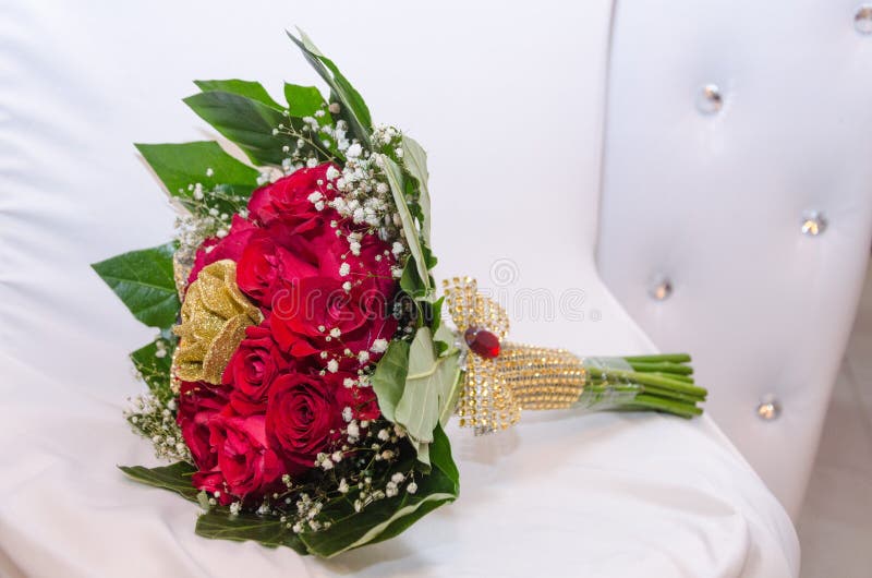 Um Ramalhete De Rosas Frescas Vermelhas E De Rosas Artificiais Douradas Com  Fita, Grânulos E Folhas Do Verde Em Uma Cadeira Branc Foto de Stock -  Imagem de felicidade, noiva: 58571824