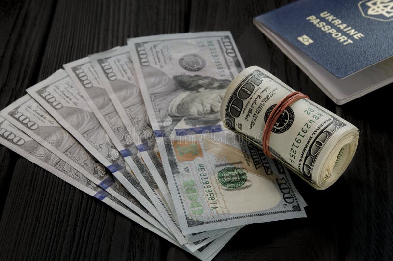 Um rolo grosso de cem cédulas velhas do dólar amarrou um elástico vermelho encontra-se na suiça de cem notas de dólar novas foto de stock royalty free Um rolo grosso de cem cédulas velhas do dólar amarrou um elástico vermelho encontra-se na suiça de cem notas de dólar novas foto de stock royalty free