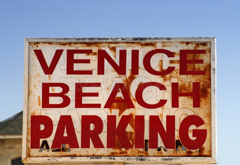Um sinal resistido velho do estacionamento da praia de Veneza