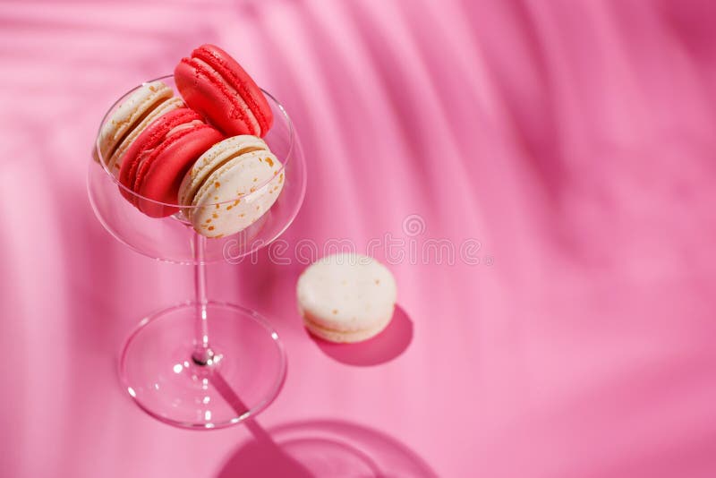 Um sortido delicioso de macarões coloridos dispostos sobre um fundo rosa vibrante fotos de stock
