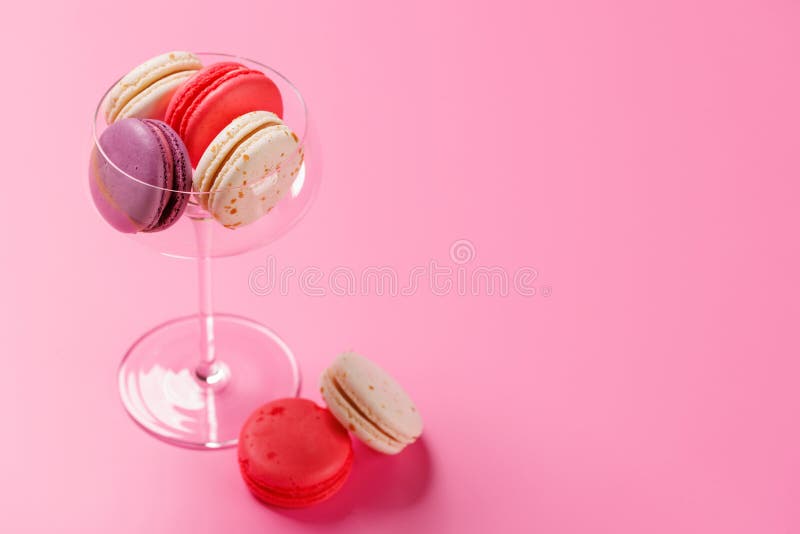 Um sortido delicioso de macarões coloridos dispostos sobre um fundo rosa vibrante fotos de stock