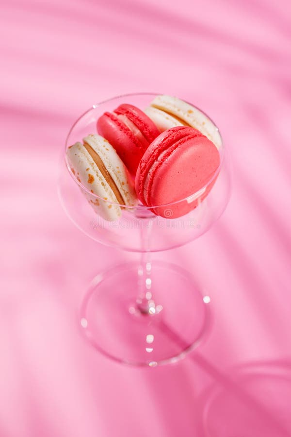Um sortido delicioso de macarões coloridos dispostos sobre um fundo rosa vibrante imagens de stock