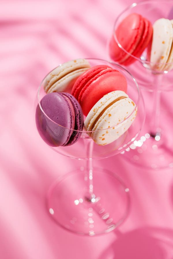 Um sortido delicioso de macarões coloridos dispostos sobre um fundo rosa vibrante fotografia de stock royalty free