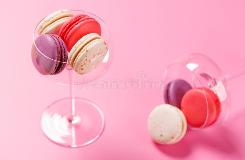 Um sortido delicioso de macarões coloridos dispostos sobre um fundo rosa vibrante fotografia de stock