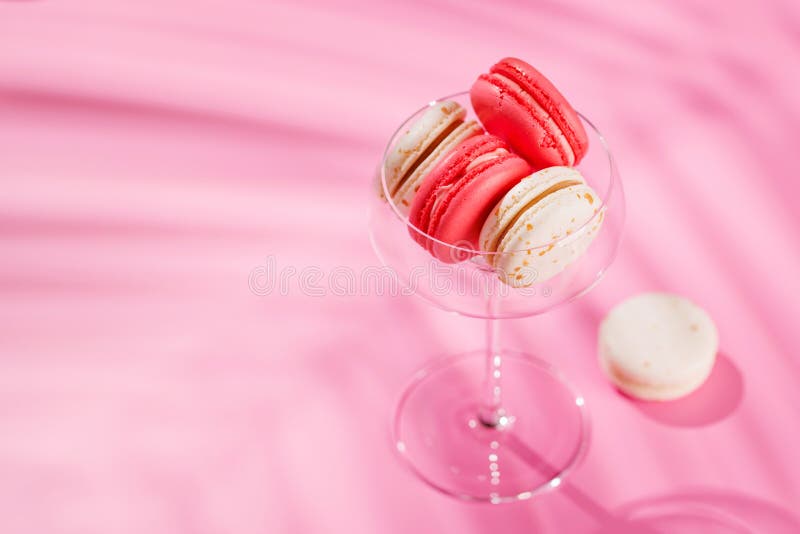 Um sortido delicioso de macarões coloridos dispostos sobre um fundo rosa vibrante fotos de stock royalty free
