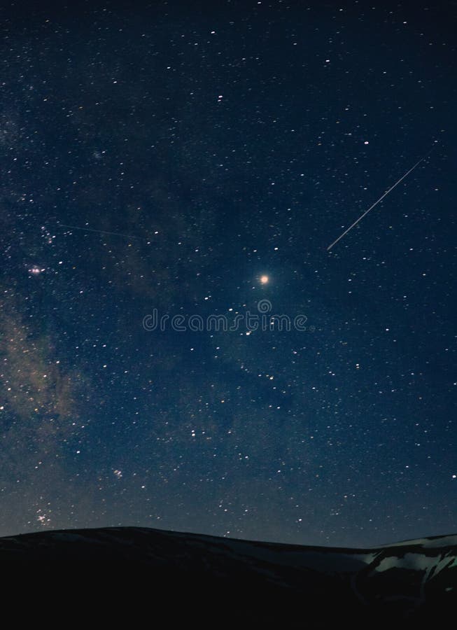 Um tiro bonito de um céu surpreendente completamente de estrelas excitantes na noite sobre os montes fotos de stock Um tiro bonito de um céu surpreendente completamente de estrelas excitantes na noite sobre os montes fotos de stock