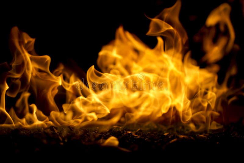 A macro shot of a flame emitting from a glass fire pit. A macro shot of a flame emitting from a glass fire pit.