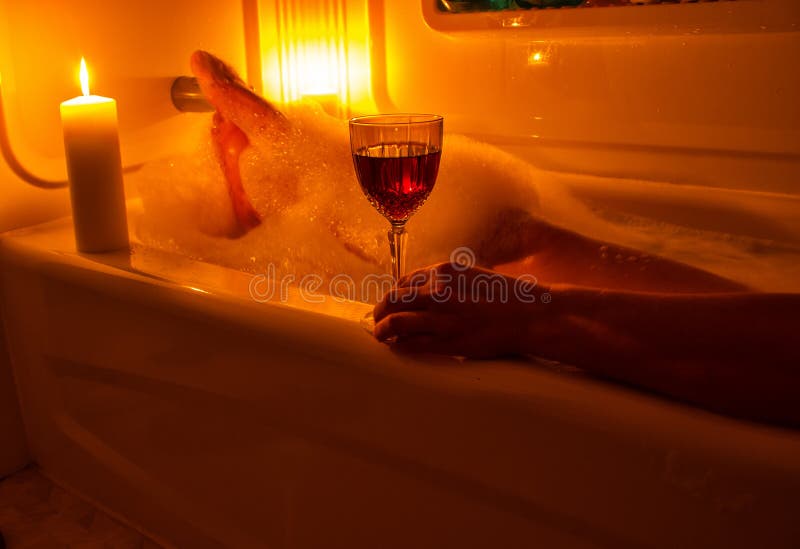 Um vidro do vinho e do banho de espuma imagem de stock royalty free Um vidro do vinho e do banho de espuma imagem de stock royalty free