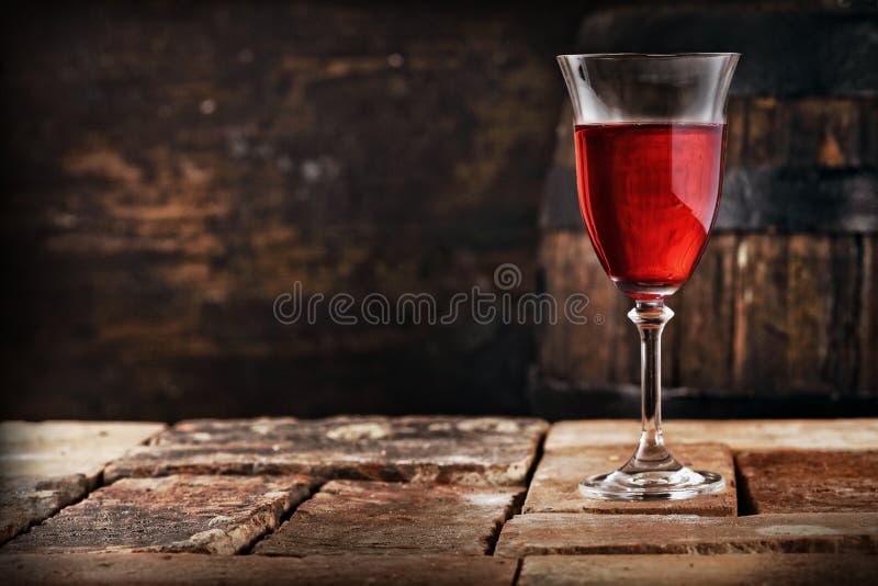 Um vidro do vinho tinto em uma tabela rústica velha
