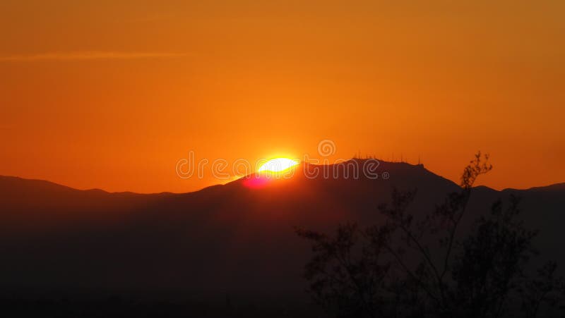 A glimpse of the setting sun as it is hiding behind the desert mountain in the valley of the sun in phoenix arizona usa. A glimpse of the setting sun as it is hiding behind the desert mountain in the valley of the sun in phoenix arizona usa.