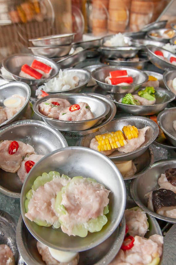 Um vário de bolinhas de massa da flâmula de Dim Sum serviu em placas de aço inoxidável pequenas em um restaurante chinês local em foto de stock Um vário de bolinhas de massa da flâmula de Dim Sum serviu em placas de aço inoxidável pequenas em um restaurante chinês local em foto de stock