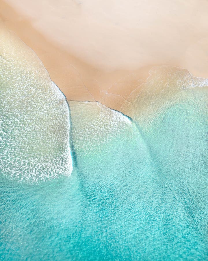 Uma antena de praia com lindas ondas, areia branca e texturas oceânicas