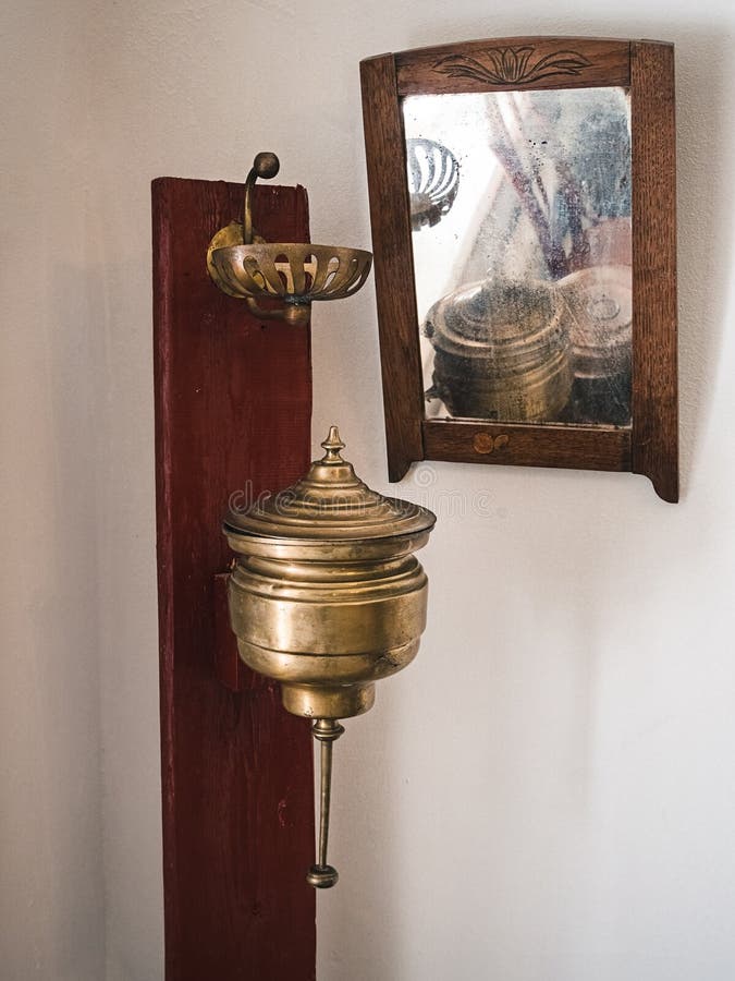Uma bacia velha de lavagem de cobre e um suporte para sabão, um espelho antigo numa armação de madeira imagem de stock royalty free Uma bacia velha de lavagem de cobre e um suporte para sabão, um espelho antigo numa armação de madeira imagem de stock royalty free