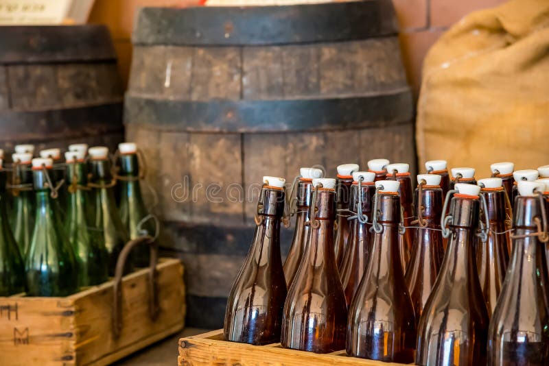 Uma caixa da garrafa empilhada sobre um tambor de madeira em um sótão de uma cervejaria da cerveja fotografia de stock Uma caixa da garrafa empilhada sobre um tambor de madeira em um sótão de uma cervejaria da cerveja fotografia de stock