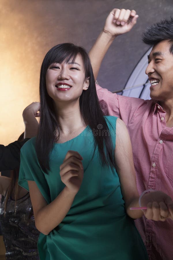 Uma dança da jovem mulher com amigos em um clube noturno fotos de stock Uma dança da jovem mulher com amigos em um clube noturno fotos de stock
