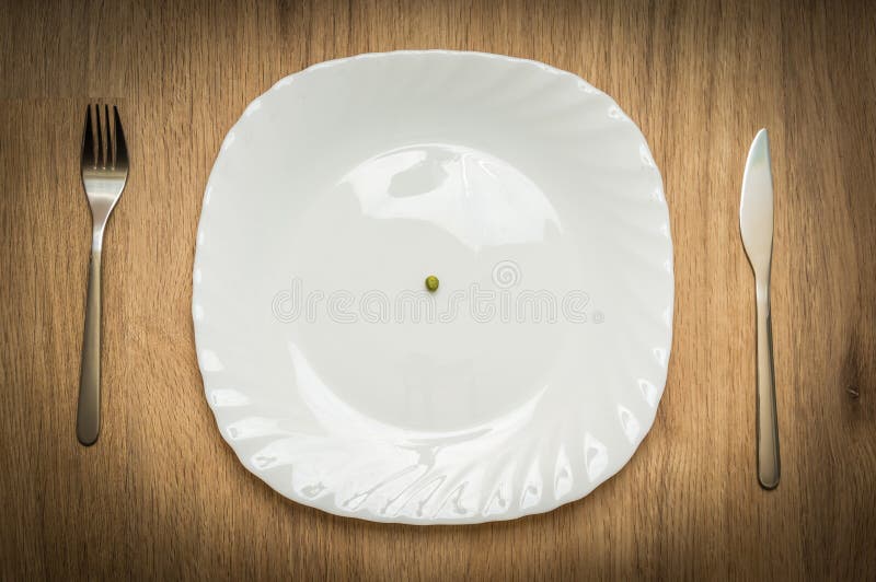 Uma ervilha verde na placa branca fotos de stock royalty free Uma ervilha verde na placa branca fotos de stock royalty free