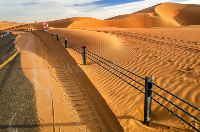 Uma estrada através das dunas de um deserto imagem de stock royalty free Uma estrada através das dunas de um deserto imagem de stock royalty free