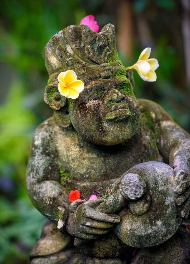 A temple statue decorated with flowers in bali,indonesia. A temple statue decorated with flowers in bali,indonesia