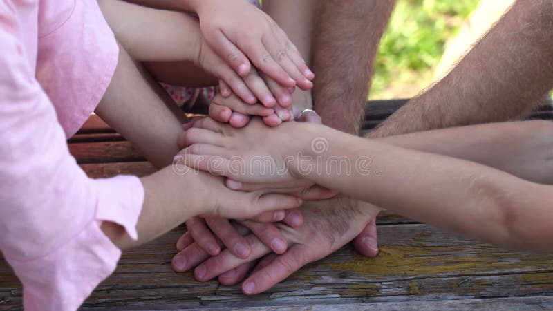 Uma família amigável junta-se às mãos como um sinal de sucesso conjunto.
