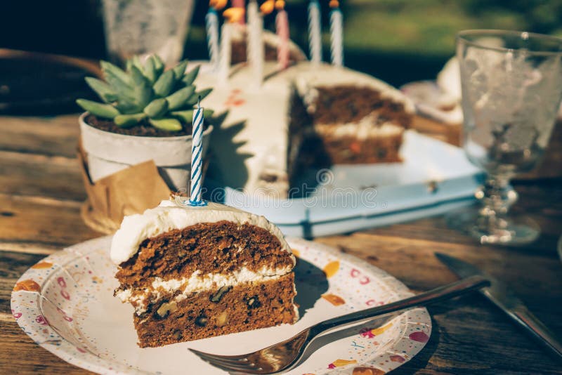 Uma fatia de bolo de cenoura caseiro com uma vela imagens de stock Uma fatia de bolo de cenoura caseiro com uma vela imagens de stock