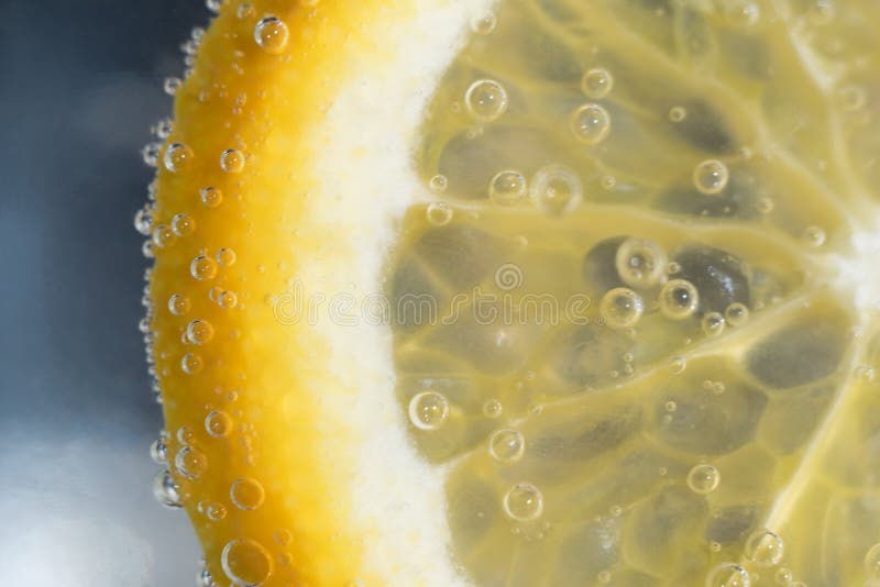 Uma fatia de laranja nas bolhas na água imagens de stock Uma fatia de laranja nas bolhas na água imagens de stock