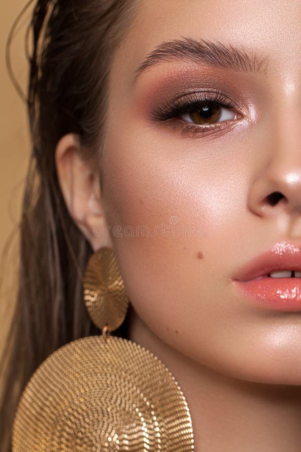 Uma foto de metade do rosto da jovem com uma abordagem forte Composição profissional, pele perfeita, brincos redondos de ouro fotografia de stock royalty free Uma foto de metade do rosto da jovem com uma abordagem forte Composição profissional, pele perfeita, brincos redondos de ouro fotografia de stock royalty free