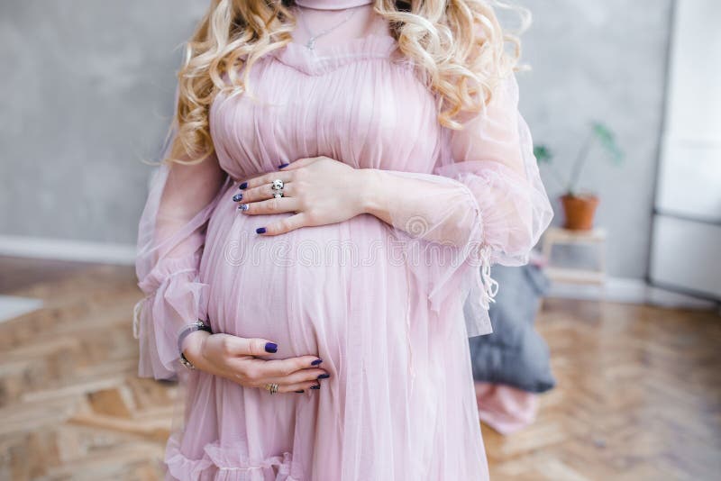 Uma foto delicada da barriga de uma menina grávida esperando um bebê que prepara-se para o parto imagens de stock Uma foto delicada da barriga de uma menina grávida esperando um bebê que prepara-se para o parto imagens de stock