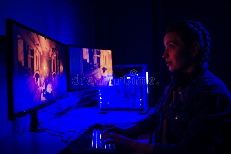 A menina com portátil joga o conceito dos jogos do vício do jogo