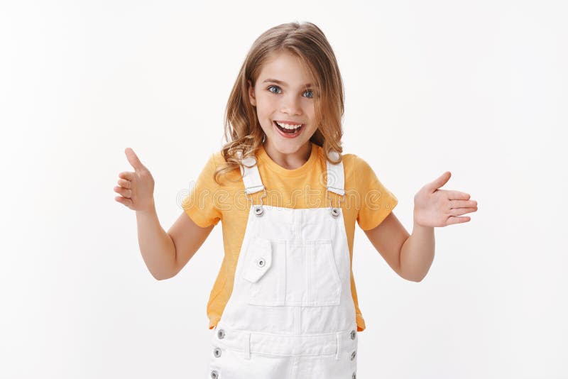 Uma garota loura fascinada e bonita explica o tamanho do produto, sorrindo animado, mostrando comprimento com as mãos discutidas fotografia de stock Uma garota loura fascinada e bonita explica o tamanho do produto, sorrindo animado, mostrando comprimento com as mãos discutidas fotografia de stock