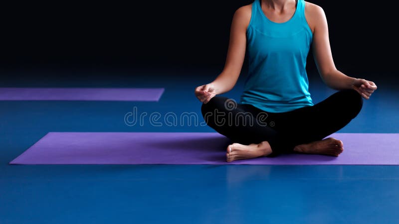 Uma ioga praticando da mulher em uma esteira imagem de stock royalty free Uma ioga praticando da mulher em uma esteira imagem de stock royalty free