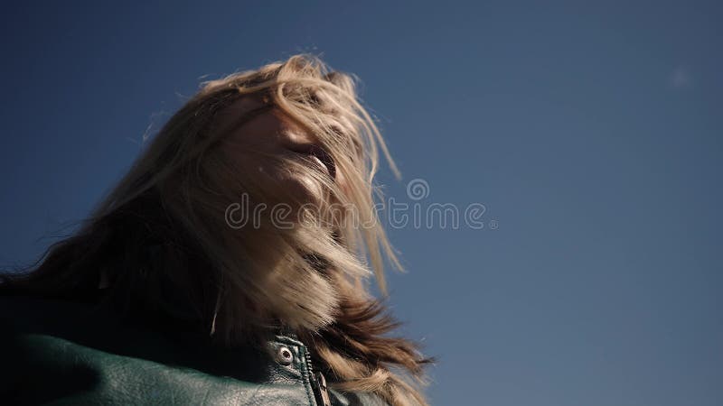 Uma jovem está desenvolvendo cabelos no céu a partir de baixo