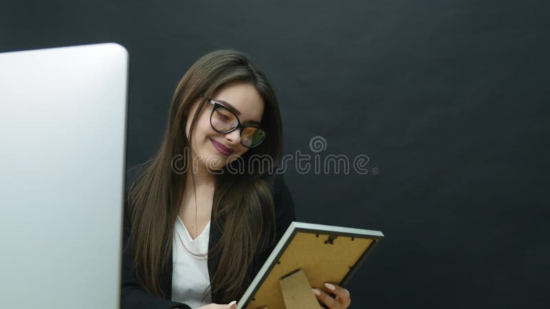 Uma jovem mulher no escritório olha a foto