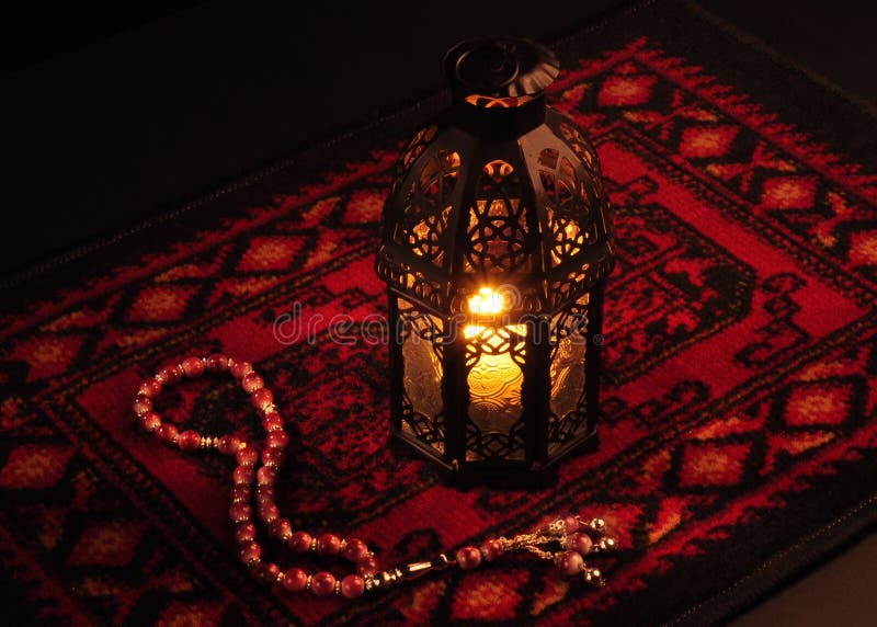 Arabic lantern on red carpet with wooden rosary. Arabic lantern on red carpet with wooden rosary