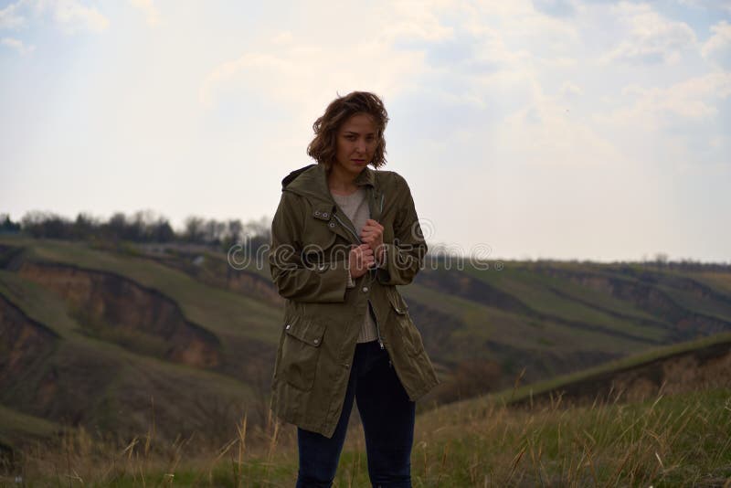 Alone girl on beautiful mountain view feeling free and lonely with wind and sky. Isolated woman on nature background, freedom concept, post apocalypse. Alone girl on beautiful mountain view feeling free and lonely with wind and sky. Isolated woman on nature background, freedom concept, post apocalypse