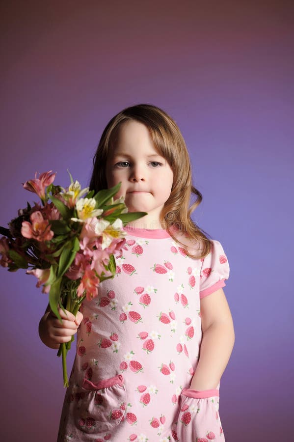 Uma linda garotinha com flores imagem de stock