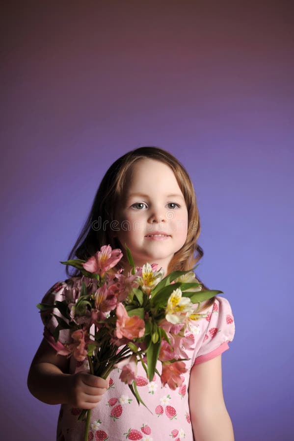 Uma linda garotinha com flores fotos de stock