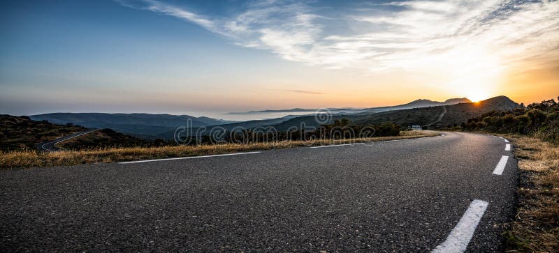 Uma longa estrada de montanha vazia para o horizonte num dia de verão ensolarado no pôr do sol brilhante