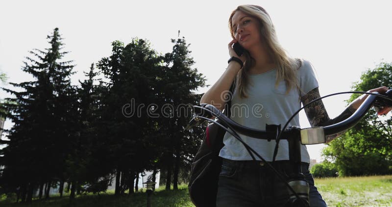 Uma menina doce responde a um telefonema no parque