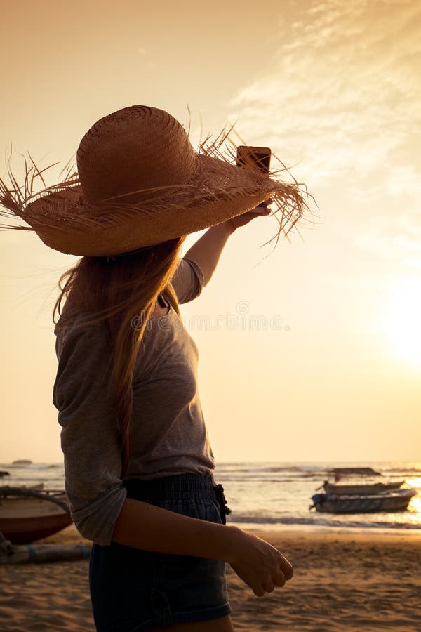 Uma menina toma uma imagem do por do sol imagens de stock Uma menina toma uma imagem do por do sol imagens de stock