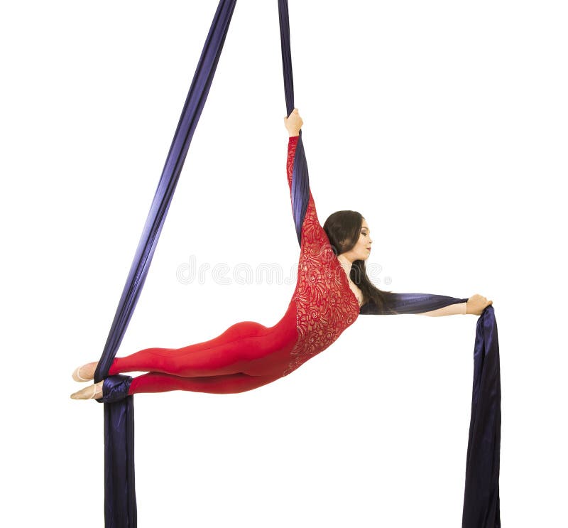 Uma moça com cabelo longo em um terno vermelho executa exercícios ginásticos e do circo na seda fotografia de stock royalty free