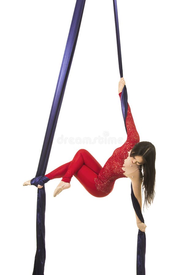 Uma moça com cabelo longo em um terno vermelho executa exercícios ginásticos e do circo na seda fotos de stock
