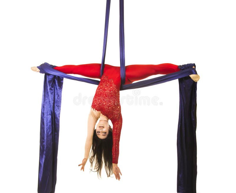 Uma moça com cabelo longo em um terno vermelho executa exercícios ginásticos e do circo na seda imagens de stock royalty free