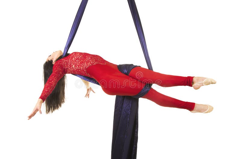 Uma moça com cabelo longo em um terno vermelho executa exercícios ginásticos e do circo na seda fotografia de stock