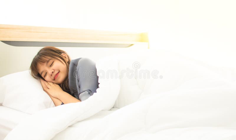 Uma mulher asiática está dormindo em sua cama imagens de stock royalty free Uma mulher asiática está dormindo em sua cama imagens de stock royalty free